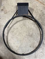 Full view of the regulation size black metal basketball rim without net.