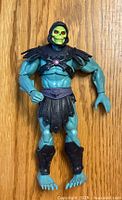 Front view of Skeletor action figure showing detailed face and armor, blue body and green skull-like head