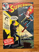 Front cover of vintage Superman comic book, issue #230, featuring an action scene with Superman and a man holding a gun, along with a wanted poster for Clark Kent.