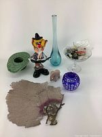 Photo showing entire assortment of vintage decor and buttons including ceramics, figurines, glassware, coral pieces, and metal item