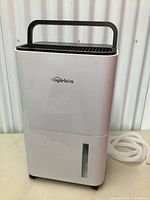 Front view of HogarLabs white dehumidifier with handle on top and water level window at bottom front.