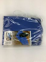 Blue folding ironing board in its carrying bag in plastic packaging.
