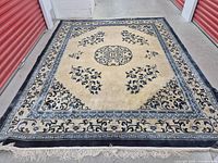 Full rectangular wool rug laid flat, showing overall pattern and colors of blue and cream with Oriental design elements.