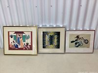 Full view of the three framed prints side by side, showing different styles and frames.