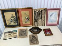 Photo showing nine assorted framed vintage art pieces of various subjects and sizes arranged together.