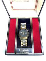 Watch inside original Seiko Quartz box with red velvet side panels and gold branding on base.