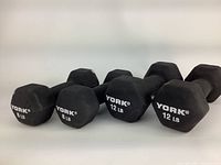 Four York hex dumbbells in black neoprene coating, two 8 LB and two 12 LB arranged side by side on white background.