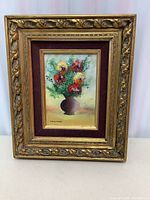 Frontal photo of the floral painting on copper by Mark Moses, showing the full framed artwork with ornate gold frame and maroon velvet inner border.