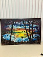 Full front view of the framed original sunset artwork showing colorful sky, tree silhouettes, and signature.