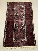 Full view of the vintage rug lying flat, showing its overall size, shape, and wear condition.