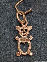 Close-up image of the gold teddy bear pendant highlighting details of the face and heart cutout body.