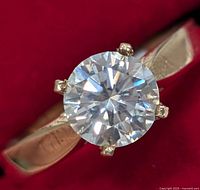 Close-up top view of ring showing round brilliant moissanite and gold band