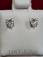 Front view showing heart-shaped cubic zirconia stones set in 14KT gold with display card marked '14KT GOLD'.