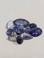 Close-up photo of various cut tanzanite gemstones showing color and shape variances.