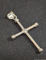 Top-down view of the silver cross pendant showing the knot detail.