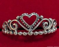 Front view showing heart-shaped open design and bead details on silver ring