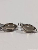 Pair of silver smokey quartz earrings from front, showing the marquise cabochon stones and silver bezel setting