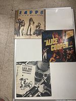 Photo showing three vinyl record albums laid out on the floor: Zoot Allures by Frank Zappa (sealed), The Alice Cooper Show by Alice Cooper, and Lace and Whiskey by Alice Cooper.