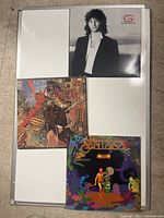 Photo of three vinyl albums: Kenny G Duotones with black and white portrait cover, Santana Abraxas with surreal colorful artwork, and Santana Amigos with vibrant psychedelic cover.