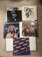 Six Peter Frampton vinyl record albums arranged on floor showing front cover art.