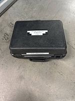 Closed black hard plastic carrying case labeled with ‘TEK LUMACOLOR II’ and S/N sticker