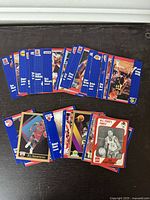 Front sides of assorted NBA basketball trading cards spread out on a surface, showing a variety of players and team logos.