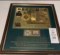 Framed commemorative collection featuring a gold foil historic map, silver coin, and postage stamp related to Columbus's 500th anniversary.