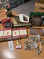 Overview of various boxed and loose Christmas ornaments and accessories on a table