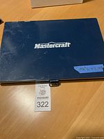 Closed blue metal case with Mastercraft logo and auction tag