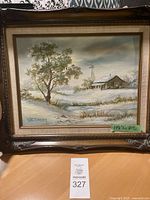 Full view of the oil painting in its frame showing winter landscape with cabin and tree.