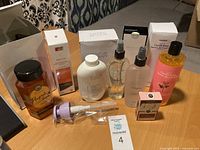 Overview of the 7 unopened toiletry products on a wooden table showing bottles, jars, and boxes.