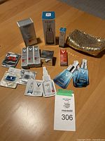 Vichy skincare products including Liftactiv Supreme cream, 89 Daily Booster serums, mineral water sachets, small boxed skincare items, samples, and a gold sequined cosmetic pouch placed on a wooden table.