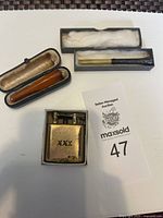 Overall view of lighter and two cheroot holders with cases