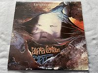 Front cover of 'Alpha Centauri/Atem' album by Tangerine Dream, showing the surreal image of a face intertwined with cosmic background, with edge wear visible.