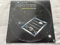 Front cover of Supertramp 'Crime of the Century' vinyl album showing space-themed artwork with hands gripping bars.