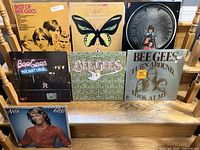 Overview photo of all six vinyl record album covers displayed on stairs showing front cover art and condition.