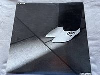 Front cover of Joe Jackson Look Sharp album, showing black and white photo with white shoes and floor pattern.