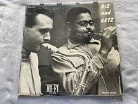 Front cover of Diz and Getz album with black and white image of musicians playing saxophone and trumpet, showing taped edges and wear
