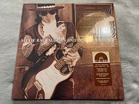 Front album cover showing Stevie Ray Vaughan in stylized costume with guitar, featuring Live At Carnegie Hall title and stickers indicating Record Store Day reissue on brown marbled vinyl