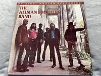 Front cover of The Allman Brothers Band vinyl album featuring band members standing by pillars.