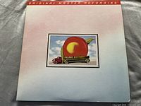 Front cover of Mobile Fidelity Sound Lab 2x vinyl LP album Eat a Peach by The Allman Brothers with peach on truck art on pink/blue gradient background.