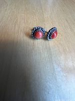 Front view showing the red coral cabochon stones with twisted sterling silver bezel.