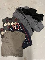 Photo showing the entire clothing lot including grey blazer jacket, black scarf, grey t-shirt, navy sweater vest, and argyle wool vest with a hole.
