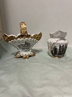 Two mini transferware dishes side by side on a surface. Left is a basket-shaped dish decorated with gold accents and a Post Office Ottawa image. Right is a small creamer with Court House London Canada image.