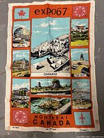 Full view of vintage Expo 67 Montreal tea towel with illustrated landmark panels and border text.
