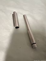 Sterling silver pen body and cap separated, showing slim cylindrical shape and open barrel end.