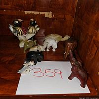 Overview of animal figurines including birds, elephants, rhino, and others arranged on wooden surface to depict overall contents.