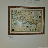 Framed vintage map displaying the Crusades routes, shields, and symbols in a wood frame.