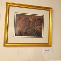 Framed print artwork showing multiple women's profiles and faces in a gold frame hung on a wall, labeled lot number 228.