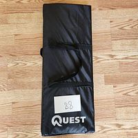 Closed black Quest branded carrying bag for the badminton set.